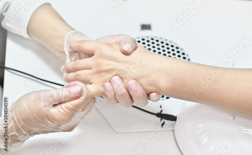 woman getting hand massage in beauty salon. client and beautician during massage procedure. professional hand skin care.