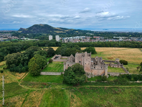 Aerial summer photo of Craigmillar Castle and gardens and Edinburgh Skyline in the background  in Scotland UK