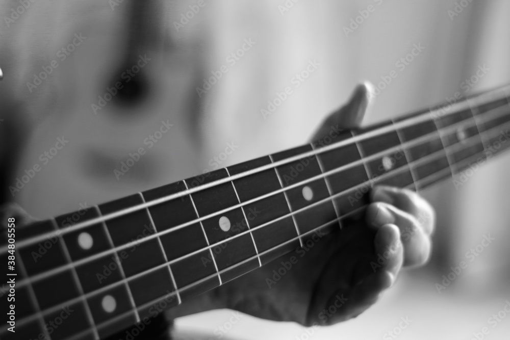 Close up of hands playing bass guitar