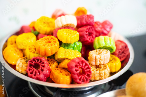 shot of colorful Fryums being deep fried in hot oil bubbling and sizzling with bubbles forming and size increasing of this popular north indian snack and street food