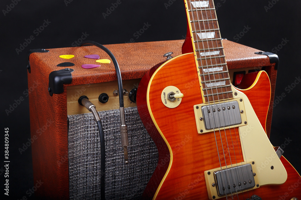 Fototapeta premium Guitar combo amplifier with guitar on black background.