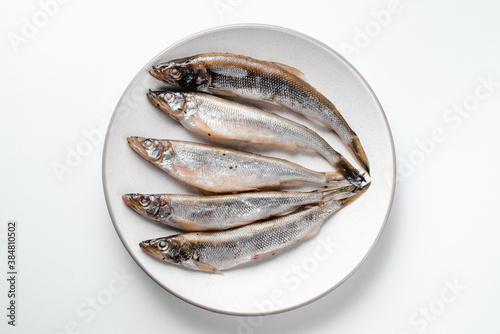 Fish lies on plate on white background
