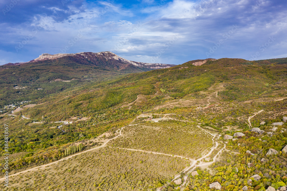 a panoramic view of the beautiful mountains with unusual ledges and rocks against the background of the sky and the valley filmed from a drone