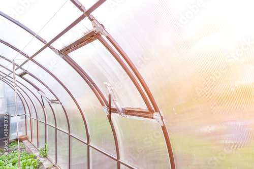 Automatic window opener in a greenhouse with a thermal drive serves to ventilate the room without human intervention - the shock absorber rod extends at high temperature and closes when it is lowered. © Aleksandr Kondratov