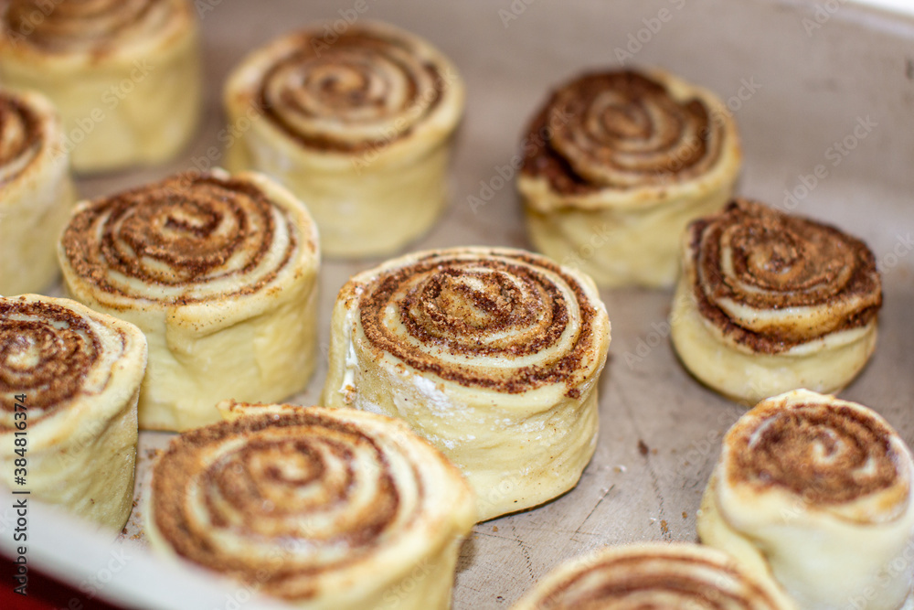 Rolled cinnamon dough on a baking sheet in the oven.