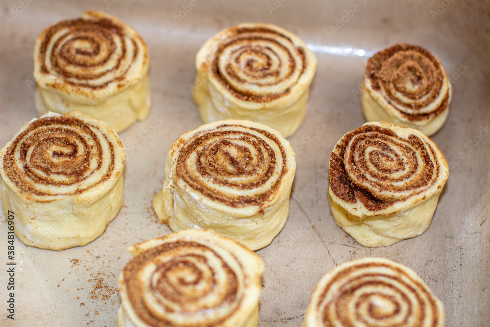 Rolled cinnamon dough on a baking sheet in the oven.