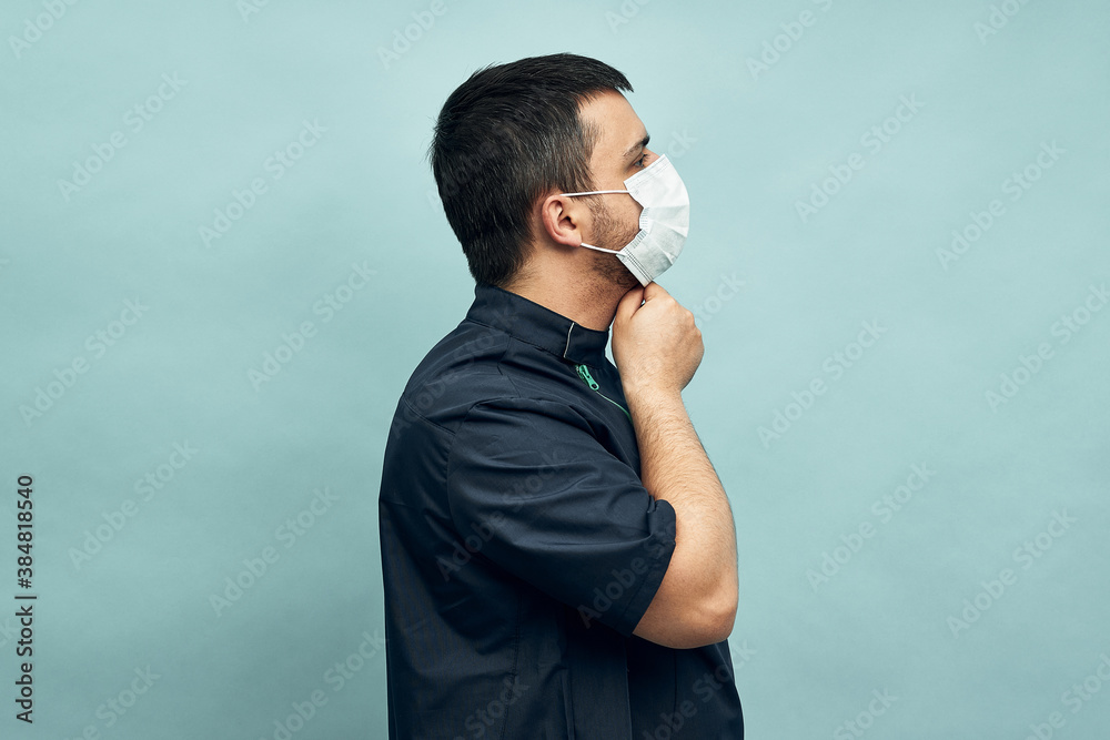 A man is putting on a protective mask. Respiratory protection from coronavirus. Personal protective equipment for a pandemic of a viral infection. Covid-19