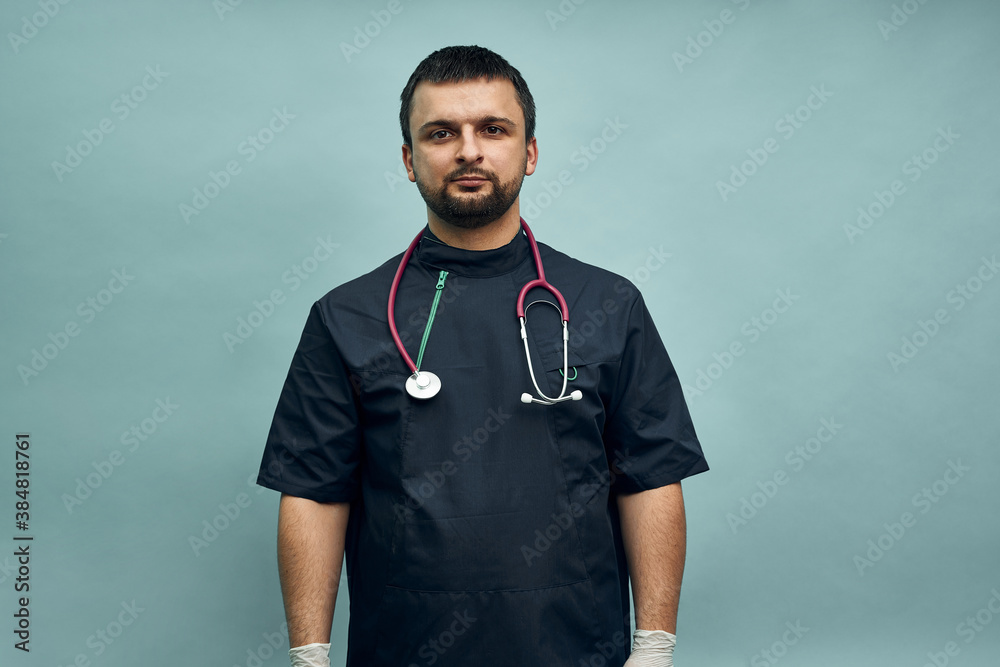 Young male doctor in professional clothes and with a stethoscope on a light blue background. Young male doctor in professional clothes and with a stethoscope on a light blue background.