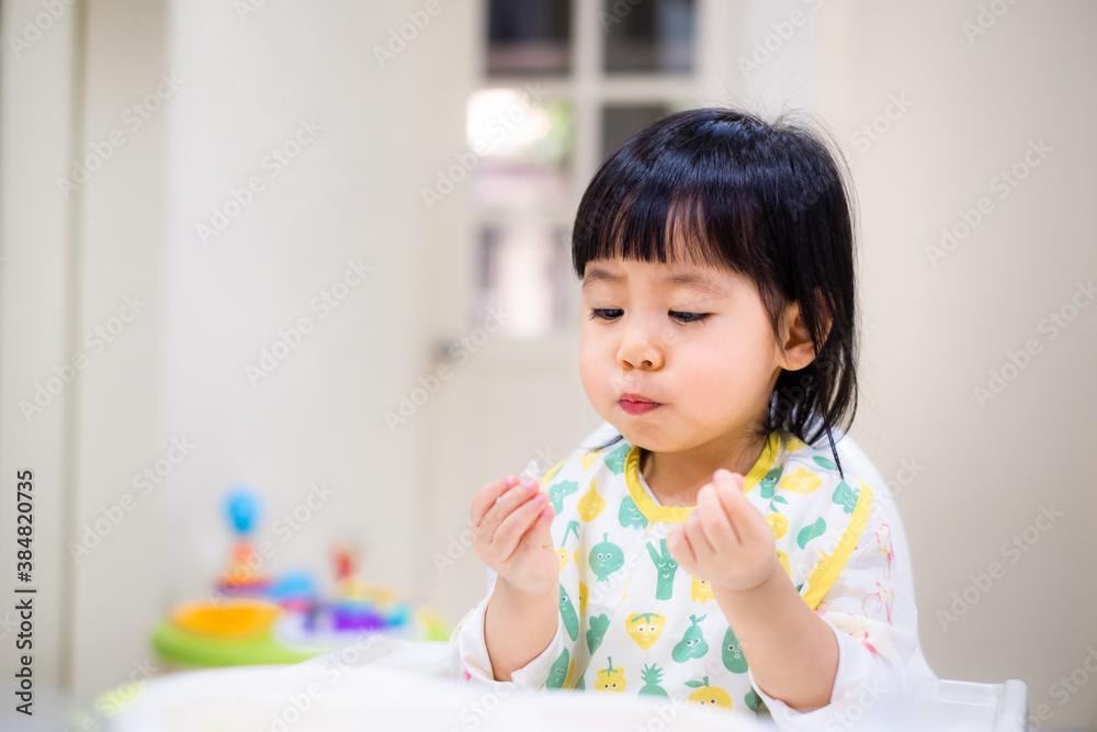 Baby eating bread. Asian baby girl enjoys a meal. baby-led weaning. Baby eating bread. Asian baby girl enjoys a meal. baby-led weaning.