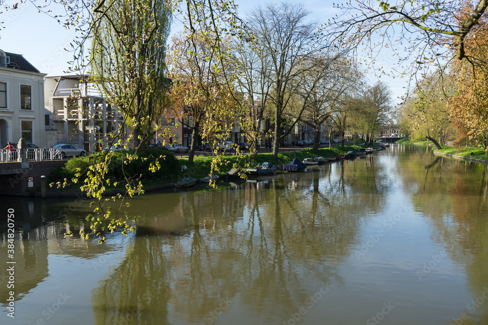 The canal or Singel in Utrecht The Netherlands on a sunny spring day with trees and boats