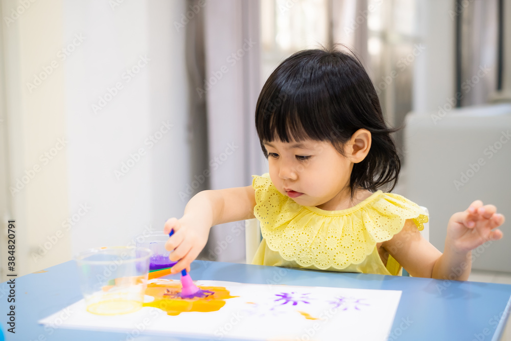 The baby girl is painting watercolor into paper. The baby girl is painting watercolor into paper.