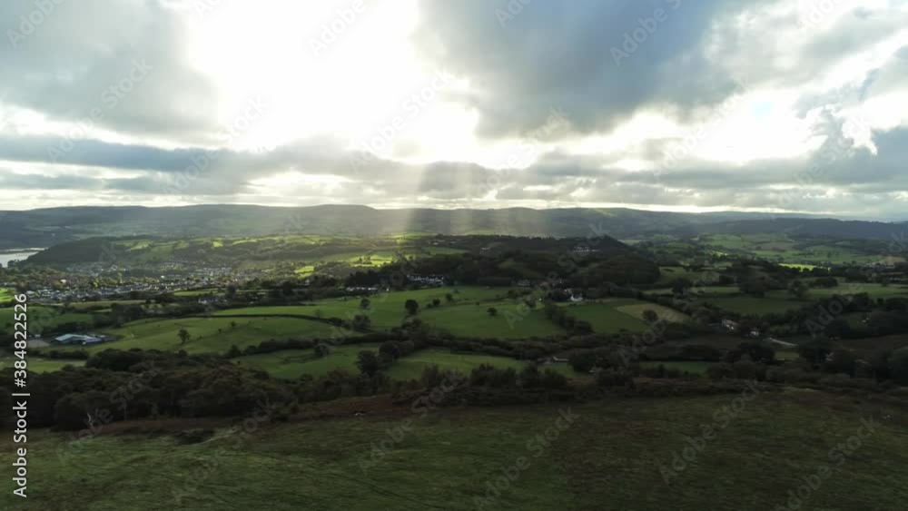 Sunbeams moving across overcast British agricultural rural village countryside morning aerial slow left dolly view Sunbeams moving across overcast British agricultural rural village countryside morning aerial slow left dolly view