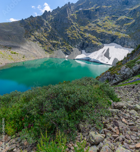 Panorama of a high-altitude lake with a glacier on the shore