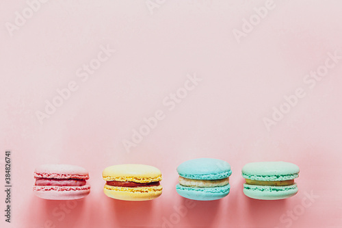 Fotografía Sweet almond colorful pink blue yellow green macaron or macaroon dessert cake isolated on trendy pink pastel background