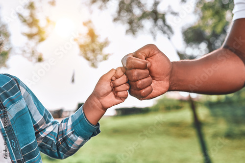 Fotografija African American kid fist-bumps hand of his dad