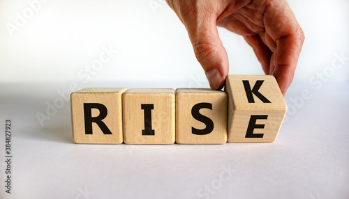 Hand flips a cube and changes the word 'risk' to 'rise'. Beautiful white background, copy space. Business concept.