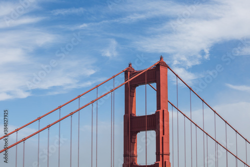The Golden Gate Bridge, blue skies and white clouds. The Golden Gate Bridge is an iconic suspension bridge located in downtown San Francisco California. © Michael Carni
