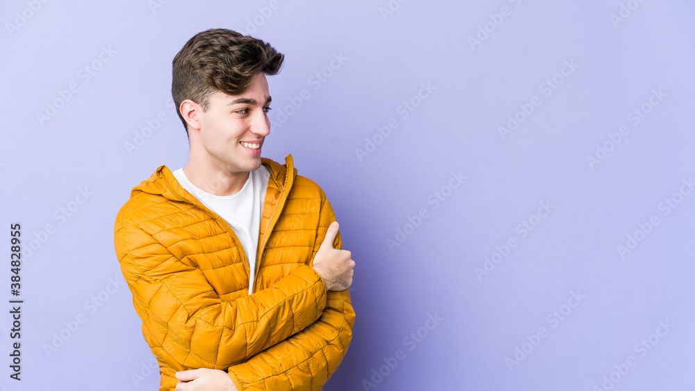 Young caucasian man isolated on purple background laughing and having fun.