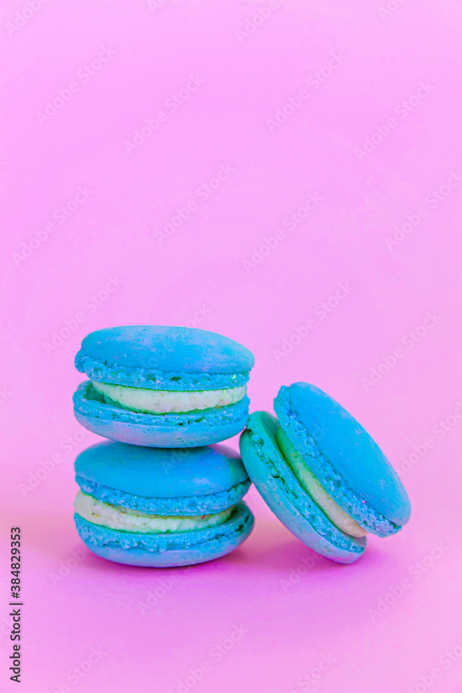 Fototapeta premium Sweet almond colorful unicorn blue macaron or macaroon dessert cake isolated on trendy pink pastel background. French sweet cookie. Minimal food bakery concept Copy space