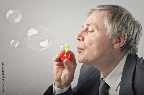 businessman plays with soap bubbles