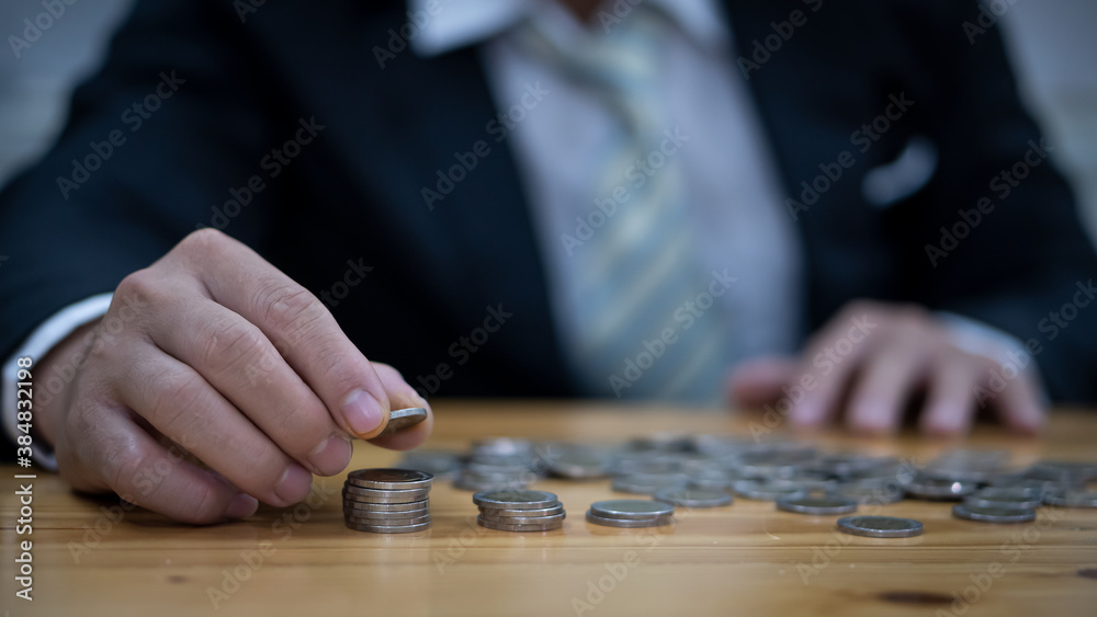 A close up of business people with a pile of silver coins on their desks A close up of business people with a pile of silver coins on their desks