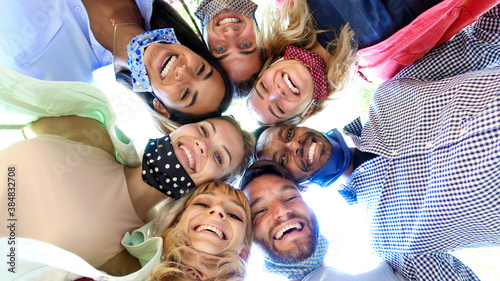 Diverse people wearing face mask taking a selfie - Portrait of a group of young friends having fun outdoor - New normal people lifestyle concept