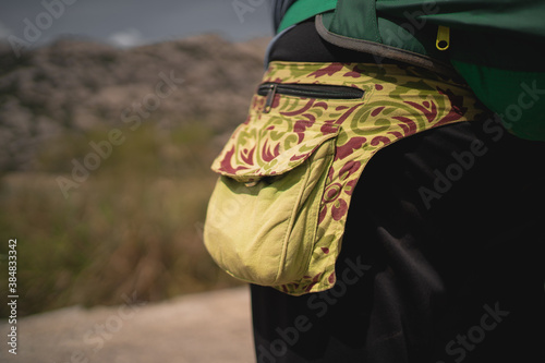 Detail of the fanny pack of a hiker during a trail in the mountains