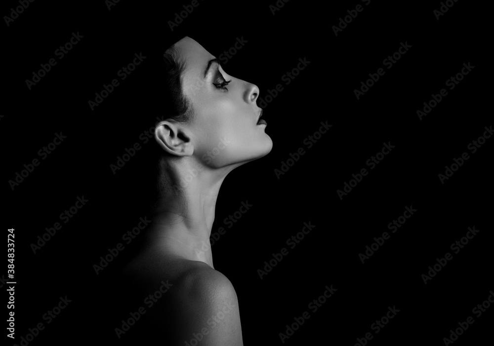 Beautiful natural elegant woman with healthy neck, nude back and shoulder on black background in fashion hat with empty copy space. Closeup profile view portrait. Art.Expression.