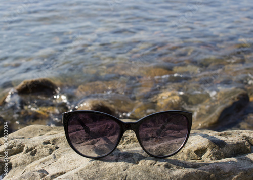 Close-up of sunglasses against the sea