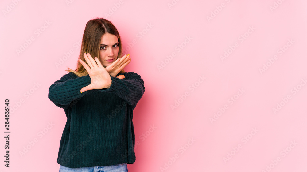 Young caucasian woman isolated on pink background doing a denial gesture