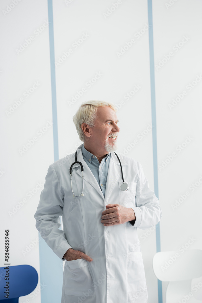 Grey haired doctor looking away while working in hospital