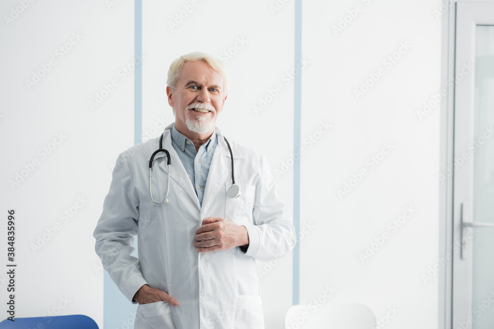 Senior doctor with hand in pocket looking at camera in hospital Senior doctor with hand in pocket looking at camera in hospital