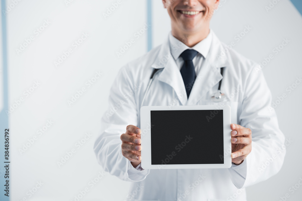 Cropped view of doctor holding digital tablet with blank screen in hospital Cropped view of doctor holding digital tablet with blank screen in hospital