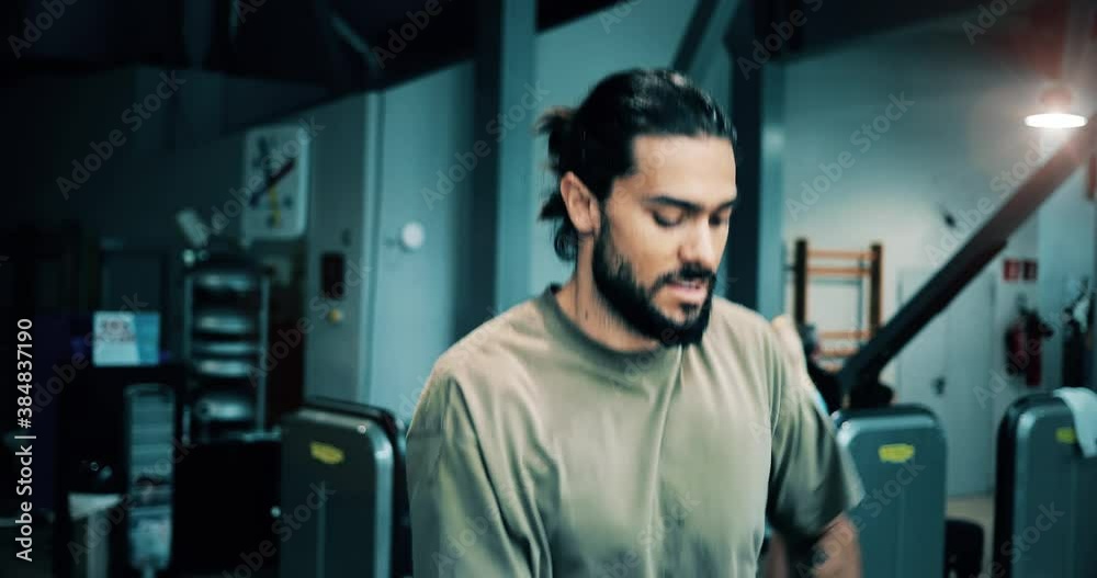 Man is running on a treadmill machine in a fitness club. He is dressed in a gray sportswear and his eyes are focused on the exercise 4K Man is running on a treadmill machine in a fitness club. He is dressed in a gray sportswear and his eyes are focused on the exercise 4K