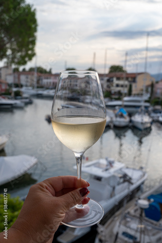 Tasting of local white wine in summer with sail boats haven of Port Grimaud on background  Provence  France