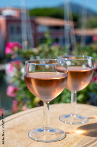 Tasting of local rose wine in summer with sail boats haven of Port Grimaud on background, Provence, France © barmalini