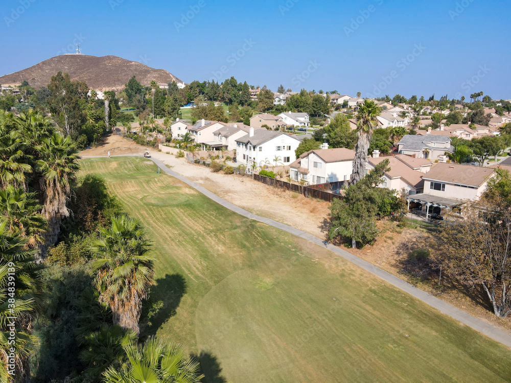 Aerial view of Southern California houses surrounded by golf in inland town Corona, during hot summer. USA