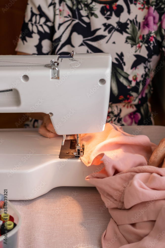 Crop view of woman working in home sewing machine