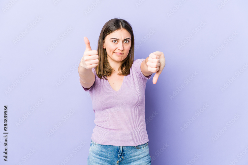 Young caucasian woman showing thumbs up and thumbs down, difficult choose concept Young caucasian woman showing thumbs up and thumbs down, difficult choose concept