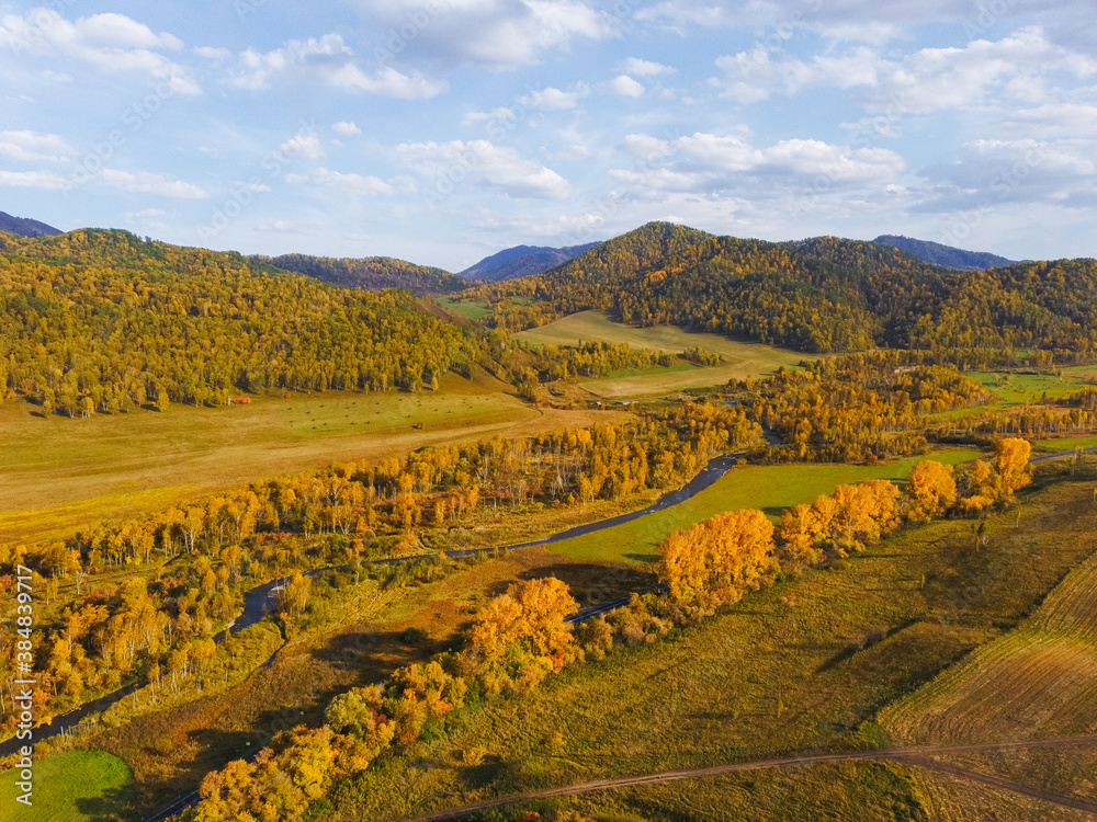Aerial view of the picturesque autumn mountains with fields of harvested and winter crops. Bright autumn colors, Drone shooting of scenic autumn backgrounds.