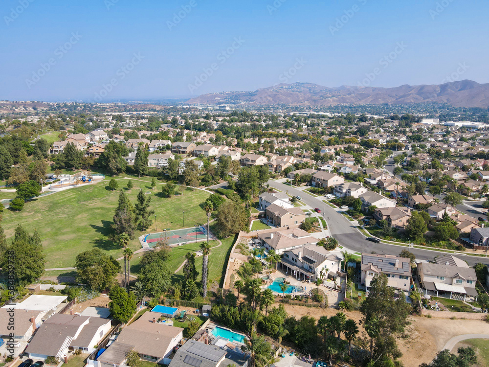 Aerial view of Southern California houses surrounded by golf in inland town Corona, during hot summer. USA