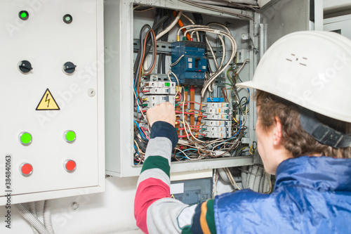 There is an equipment check in the electrical control room. Switching off switches in the cabinet. Electrician works in a communication box photo