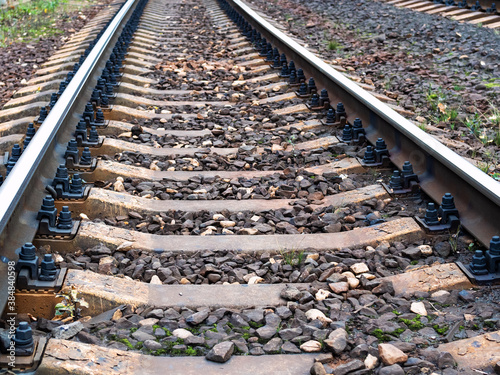 low view of rails of railroad track with concrete sleepers in Moscow region in evening