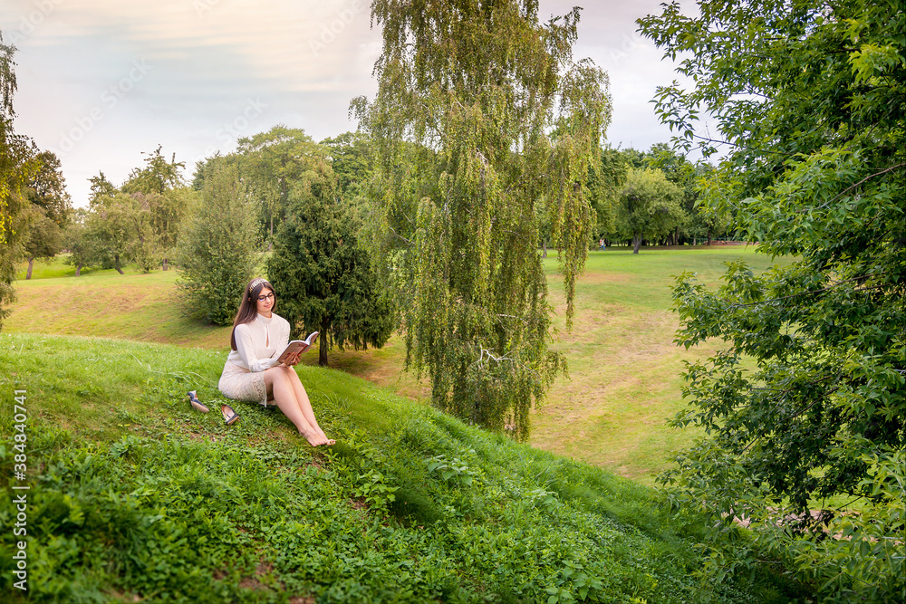 Girl reading a book on a hill. Girl reading a book on a hill.