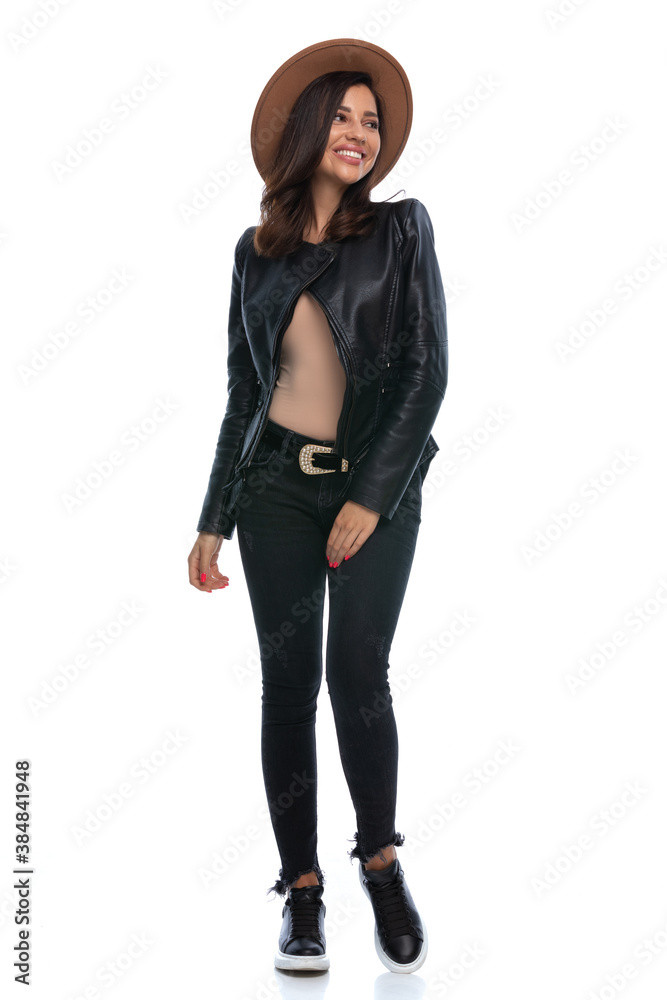 Cheerful casual woman smiling and looking over shoulder, wearing hat Cheerful casual woman smiling and looking over shoulder, wearing hat