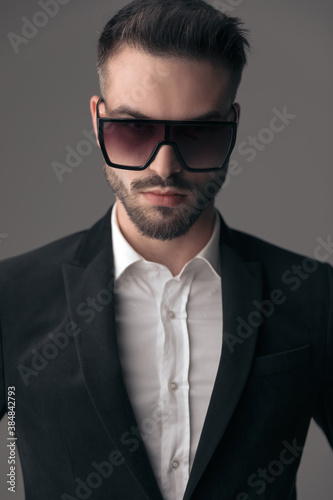 Closeup of determined fashion model wearing suit and sunglasses