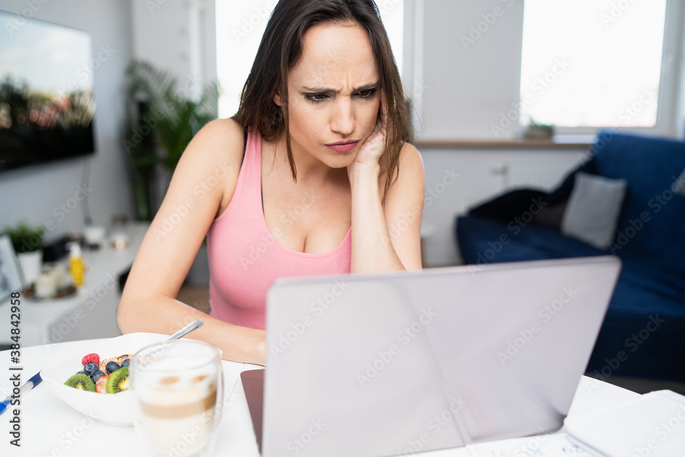 Focused pregnant woman analyzes the results of blood tests that she received via email. There is coffee and porridge on the table. Focused pregnant woman analyzes the results of blood tests that she received via email. There is coffee and porridge on the table.
