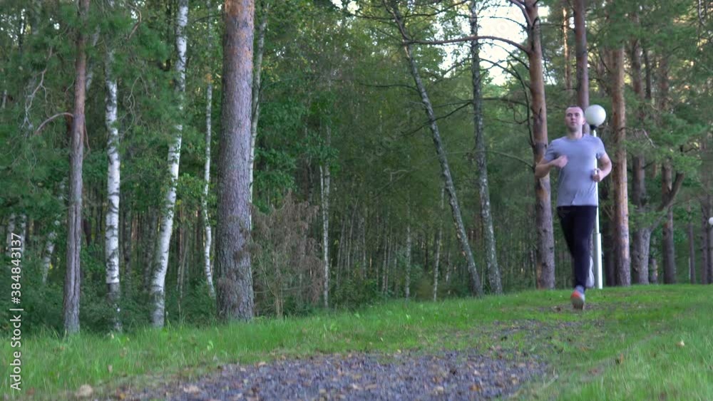 Young athletic caucasian man in sport clothing jogging running on nature during summer sunset. Handsome guy with muscular body workout of fresh air. Training in forest. Concept Healthy Lifestyle 4k Young athletic caucasian man in sport clothing jogging running on nature during summer sunset. Handsome guy with muscular body workout of fresh air. Training in forest. Concept Healthy Lifestyle 4k