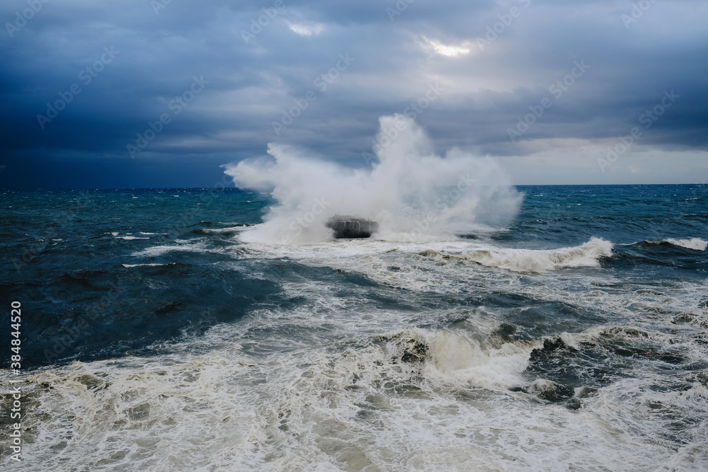  Wave crashing against a rock in the sea on a stormy day. Villaricos, Almería, Andalucía, Spain.