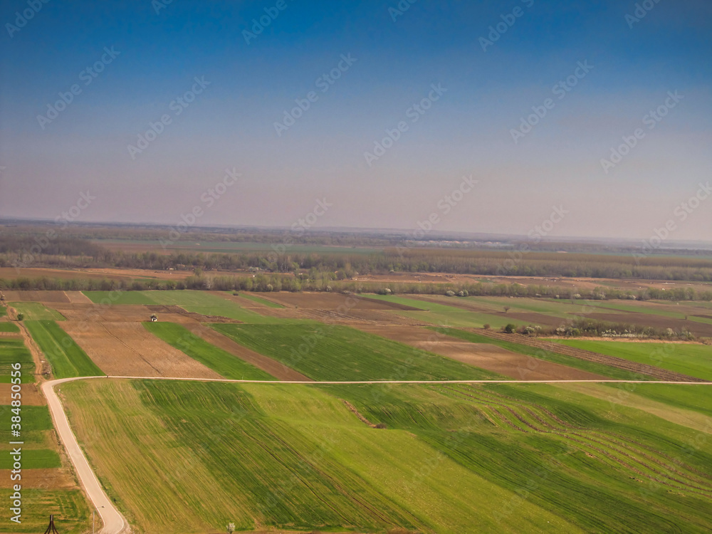 bird's eye view of colorful fields and meadows with a visible skyline, Serbia in the Balkans,